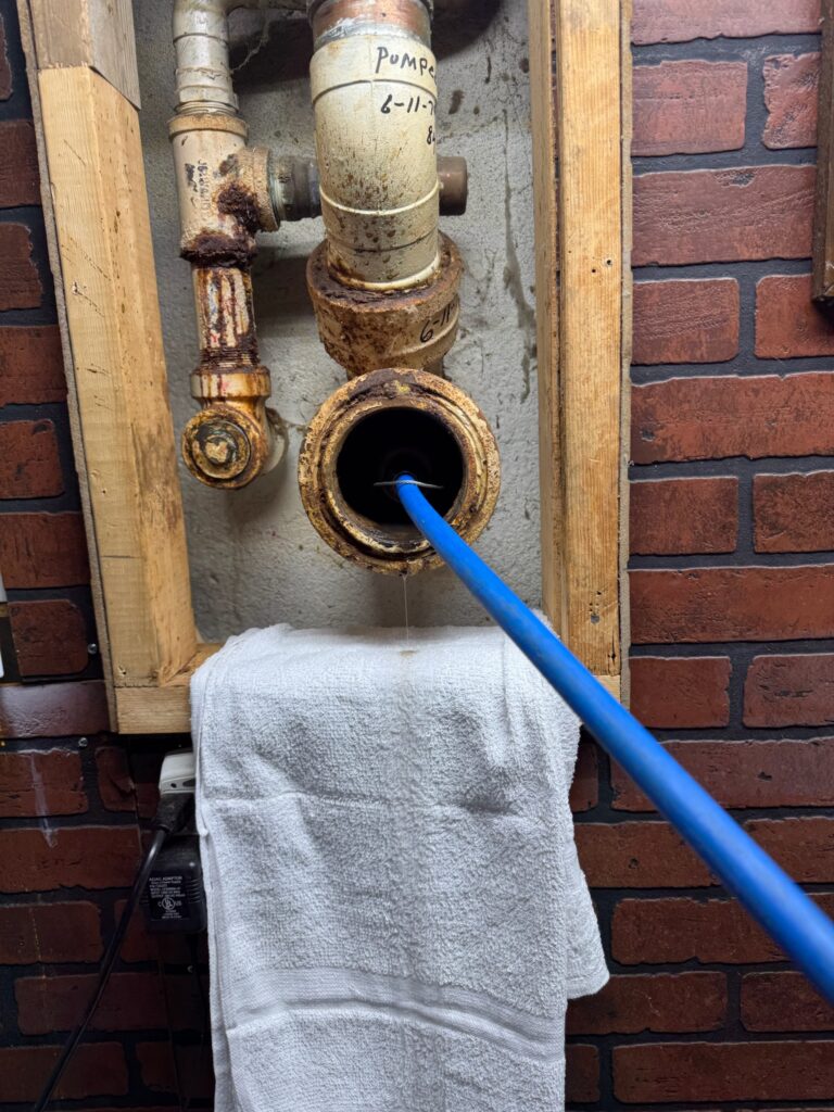 Professional drain cleaning service in progress at an Ann Arbor, MI home with cable equipment clearing a clogged pipe.